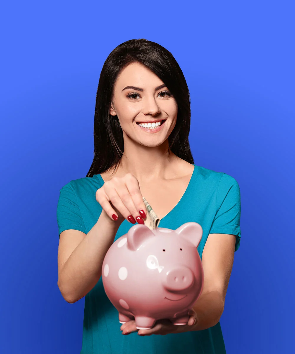 Young woman putting money into a piggy bank